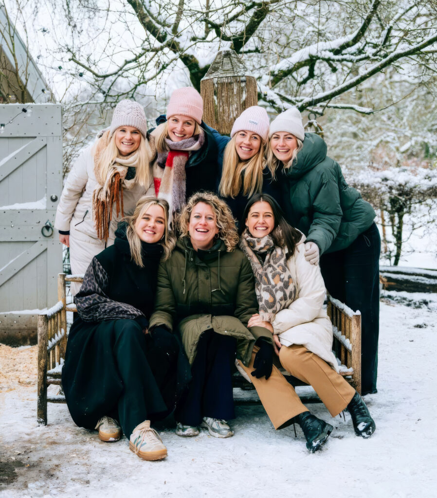 Het team van Myles lacht samen in de sneeuw