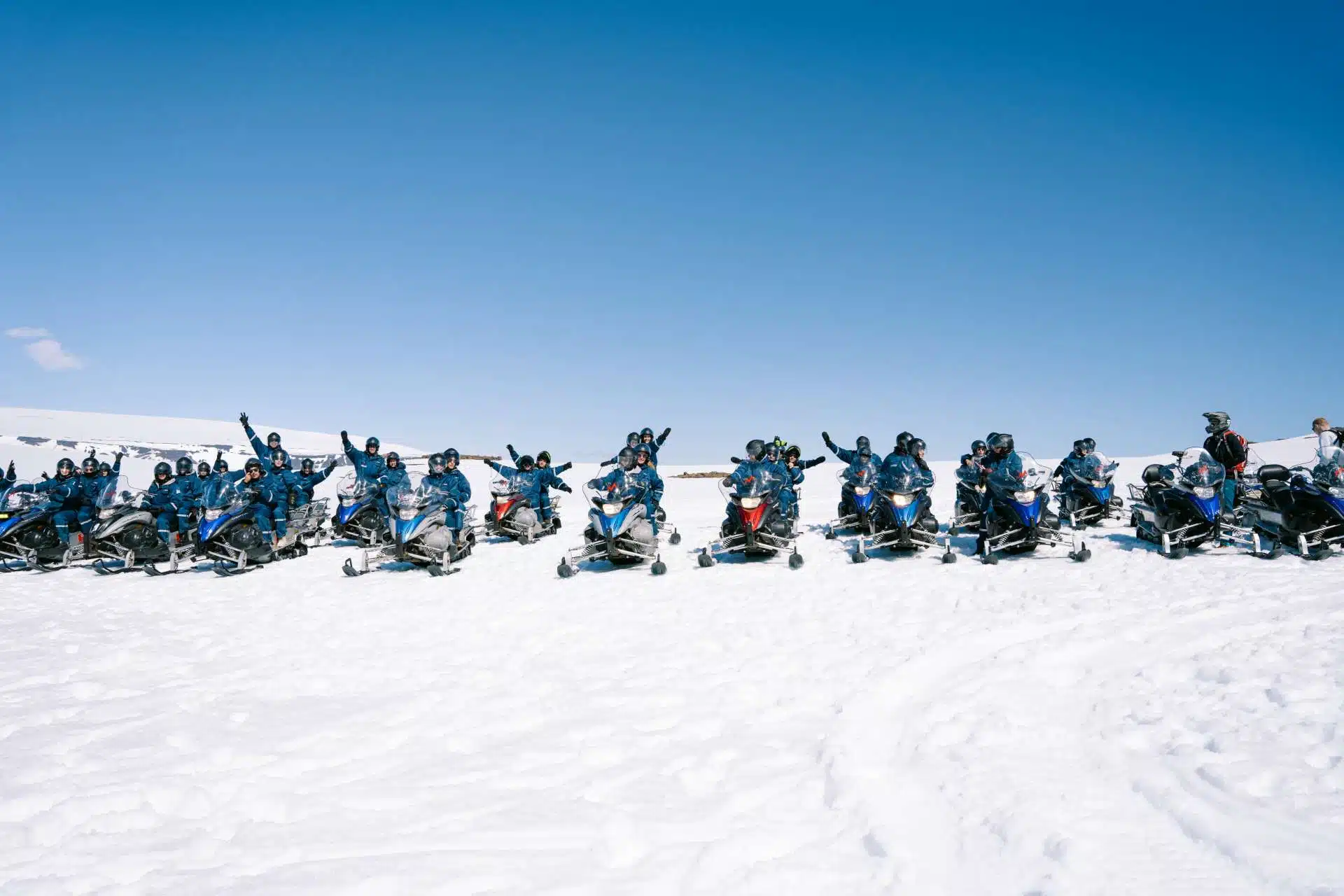 Een rij sneeuwscooters op een besneeuwde vlakte